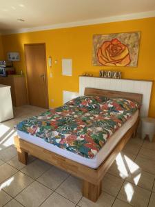ein Schlafzimmer mit einem Bett mit einer bunten Decke darauf in der Unterkunft Ferienwohnung auf dem Kutzenberg in Altendorf