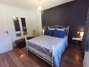 1 dormitorio con cama blanca y almohadas azules en Gîte de la Ferme de la Terve en Bruailles