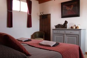 una camera da letto con due letti con lenzuola rosse e una finestra di Appartement El Balcon ( cortijo La Cubertilla) a Fuente-Tójar