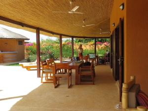 une salle à manger avec une table et des chaises sur une terrasse dans l'établissement Villa Rebecca, à Nianing