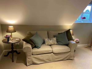 a living room with a couch and a table at Stylish getaway in the heart of the Pewsey Vale in Pewsey