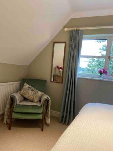 1 dormitorio con cama, silla y espejo en Stylish getaway in the heart of the Pewsey Vale en Pewsey