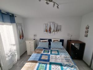 a bedroom with a bed with a blue comforter at Cap Capistol Golf, appartement 2 chambres in Cap d'Agde +29 photos