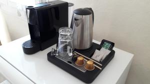 a black coffee maker on a white table at Logis Hôtel Lafayette Rochefort France in Rochefort