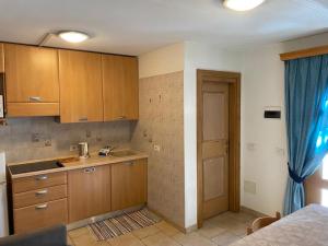 een keuken met houten kasten en een blauw gordijn bij Appartamento Piz Orsera in Livigno