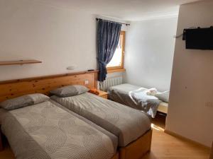 een slaapkamer met twee bedden en een raam bij Appartamento Piz Orsera in Livigno