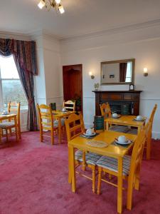 una sala da pranzo con tavoli, sedie e specchio di Eddlewood Guest House a Lerwick