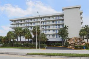 um grande edifício branco com palmeiras em frente em Motel 6-Cutler Bay, FL em Cutler Bay