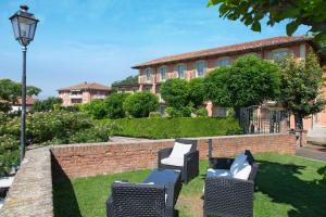 um jardim com duas cadeiras e uma parede de tijolos em Hotel Castello di Santa Vittoria em Santa Vittoria dʼAlba