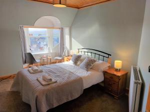 a bedroom with a large bed with towels on it at Eddlewood Guest House in Lerwick