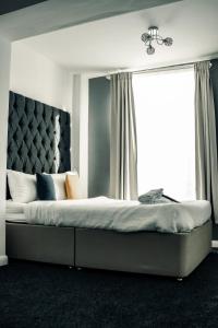 a bedroom with a large bed with a large window at Dealhouse Apartments 10 in Huddersfield