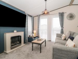 een woonkamer met een bank en een open haard bij Fairways 4 - Sunny Meadows in Burnham on Sea