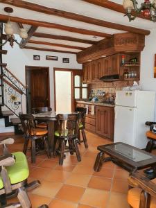 cocina con mesa, sillas y nevera blanca en Cabañas la villa, en Villa de Leyva
