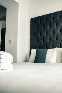 a bedroom with a bed with a black headboard at Dealhouse Apartments 10 in Huddersfield