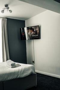 a bedroom with a flat screen tv above a bed at Dealhouse Apartments 10 in Huddersfield