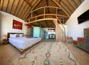 a bedroom with a large bed and a wooden ceiling at Westpoint Dakhla in Dakhla