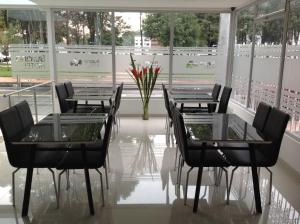 Hotel Burana في بوغوتا: مجموعة طاولات وكراسي في غرفة بها نوافذ