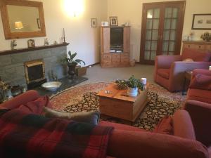 a living room with a couch and a fireplace at Great location for golf, beach, viewing dolphins. in Fortrose
