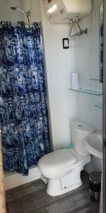 a bathroom with a toilet and a shower curtain at Santa Monica in José Ignacio