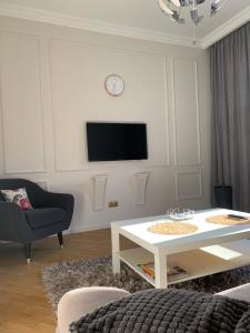 a living room with a table and a tv on a wall at KAZA APART in Minsk
