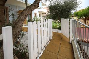 a white picket fence in front of a house at KATE HOME in Viddalba