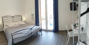 a bedroom with a bed and a table and a desk at Residenza Tarzanà in Palermo