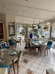 a restaurant with tables and chairs in a room at Logis Hôtel Restaurant Chez Nous in Sainte-Croix