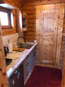 a kitchen in a log cabin with a sink at Inni Järve Puhkemaja in Vidriku Asundus