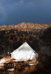 Zion View Camping في Hildale: خيمة مع كرسيين وطاولة في الليل