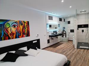 1 dormitorio con 1 cama con una pintura en la pared en Ca la Núria en La Seu d'Urgell