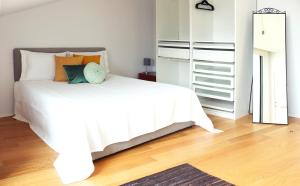 una camera da letto con un letto bianco e cuscini sopra di Villa Invicta II a Porto