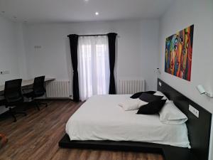 - une chambre avec un lit et un bureau avec des chaises dans l'établissement Ca la Núria, à La Seu d'Urgell