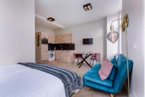 1 dormitorio con 1 cama y 1 sofá azul en Novallure Short Stay Apartments en Leidschendam