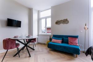 sala de estar con sofá azul y mesa en Novallure Short Stay Apartments en Leidschendam