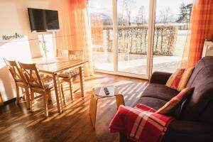 a living room with a table and a couch and a table and chairs at Vitalpark Blaichach Burgberg in Burgberg
