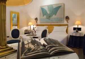 una camera con due letti e un libro su un tavolo di Hotel Locanda Cairoli a Roma
