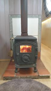 a black stove with a fire in a room at NEW 2022! Fixed stay characterful narrowboat at the Kelpies, Marigold Sunset in Falkirk