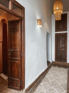 an open wooden door in a room with a rug at Riad Sierra in Marrakesh