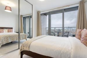 a bedroom with a bed and a large window at Modern 1 Bedroom Apartment Near Canary Wharf with Balcony in London