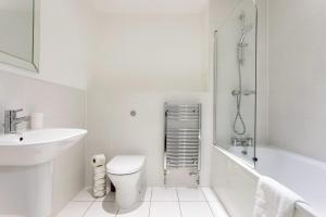 a white bathroom with a toilet and a sink at Modern 1 Bedroom Apartment Near Canary Wharf with Balcony in London