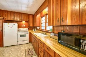 a kitchen with wooden cabinets and a white refrigerator at King House in Lake Junaluska