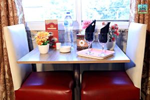 a table with two wine glasses and flowers on it at Hotel Tulip Inn, Gulberg in Lahore