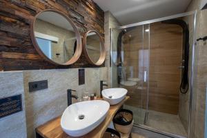 a bathroom with a sink and two mirrors at Hostal Casa Mercedes in Nerja