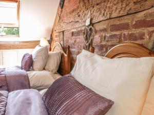 ein Wohnzimmer mit einer Couch und einer Ziegelwand in der Unterkunft Garden Cottage in Ludlow