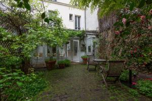 a patio with chairs and a table in a building at Veeve - Charming Townhouse near Parc Montsouris in Paris