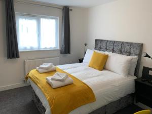 a bedroom with a large bed with two towels on it at Paddington by Pureserviced in Plymouth