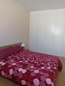 sypialnia z łóżkiem z fioletowo-białą kołdrą w obiekcie Apartamento Barbadillo - Redmansur w mieście Cáceres