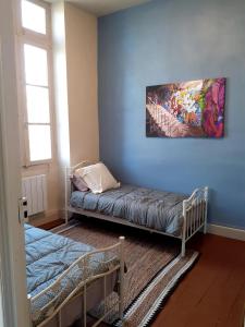 a room with a bed and a painting on the wall at Le Petit Figuier in Villefranche-du-Périgord