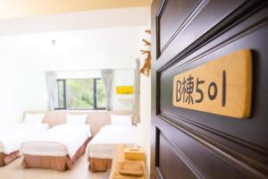 una camera con 2 letti e una porta scorrevole di 亞窩行館 Yao Guesthouse a Nangan