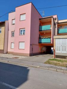 a pink building on the side of a street at Apartman Ares in Osijek